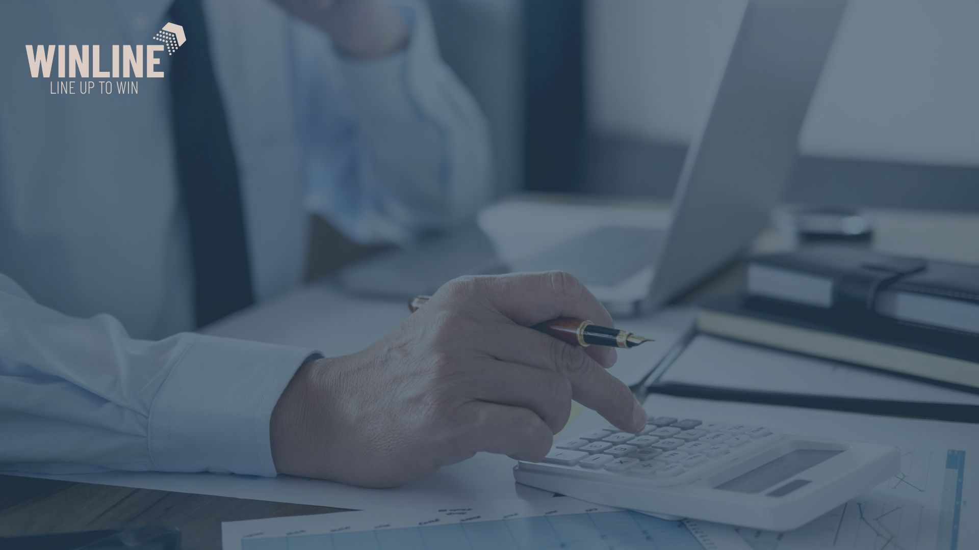 Analiza wyników finansowych firmy – mężczyzna pracujący przy biurku z laptopem i kalkulatorem